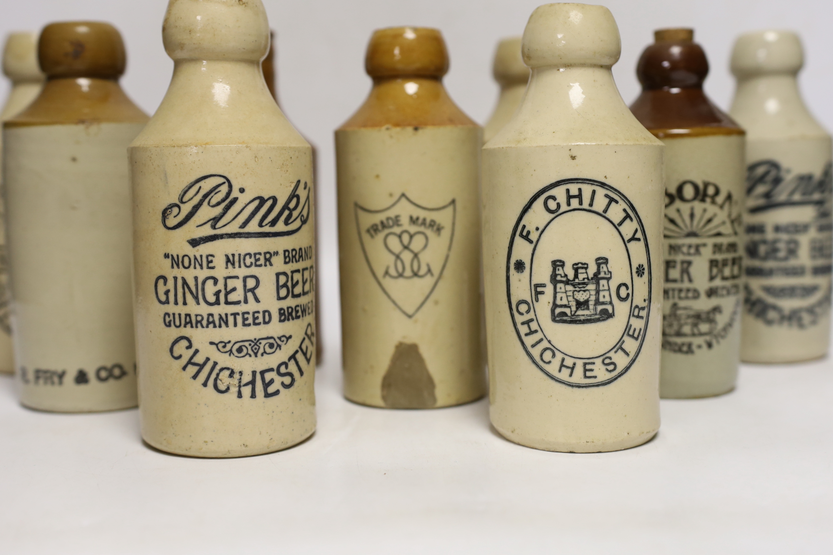 Early 20th century stoneware ginger beer bottles, six from Chichester and four others